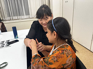 ミトゥさんの手を取って手話を教えるビャンバさん