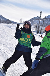 スキー研修で雪山を笑顔で滑るミトゥさん