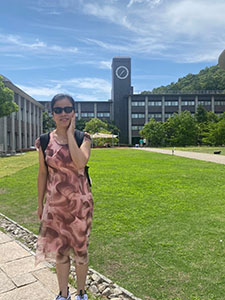 立命館大学の時計台をバックに笑顔のアンさん